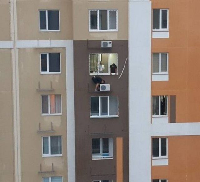 funny pictures of bad ideas, two men on the side of their building fixing an air conditioner