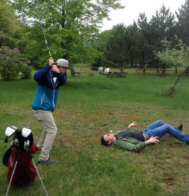 funny pictures of bad ideas, two men playing golf with one holding the golf tee in his mouth