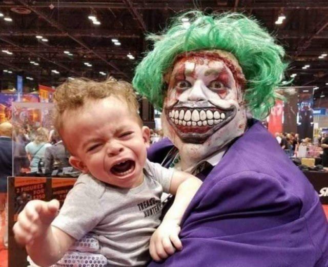 funny pictures of bad ideas, man wearing full joker make-up holding crying child