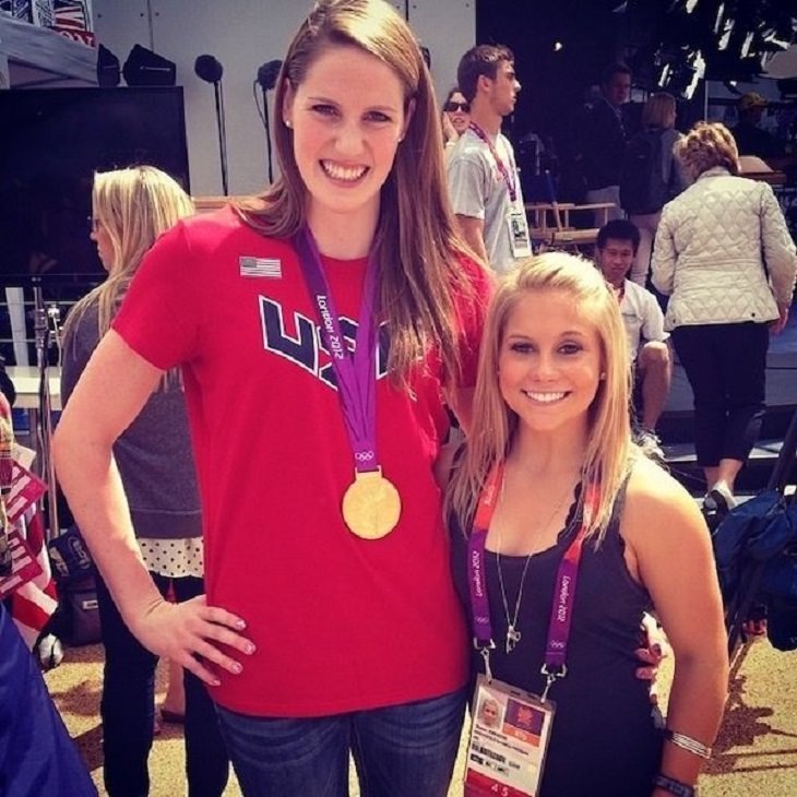 difference in comparison of random things, two women standing next to each other, one tall and brunette and the other shorter and blonde, both olympic winners in gymnastics and swimming respectively