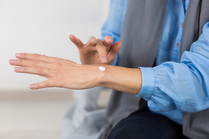 keratosis pilaris treatment, person in blue shirt applying moisturizer to hand