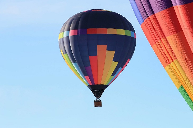 Different Hot air Balloons from Around the World, New 2017 Cameron Hot Air Balloon in flight, dark blue and rainbow hot air balloon