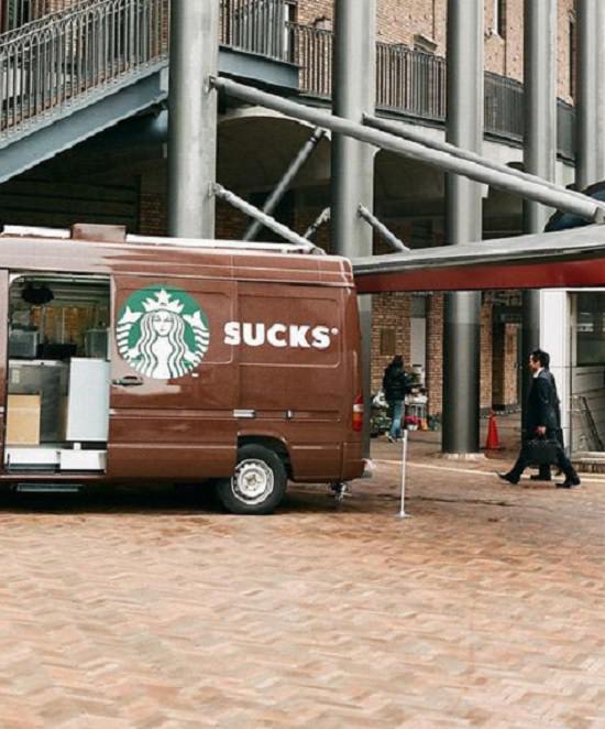 Perfectly-timed Photographs, truck of Starbucks with open sliding doors spelling out the word 'sucks'
