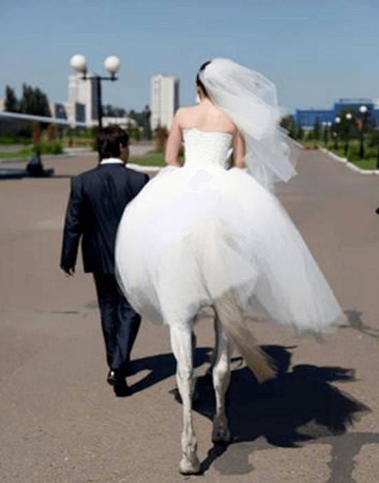 Perfectly-timed photographs, man in suit walking next to bride riding on horse, with dress covering upper half of horses body, showing a bride with horses legs