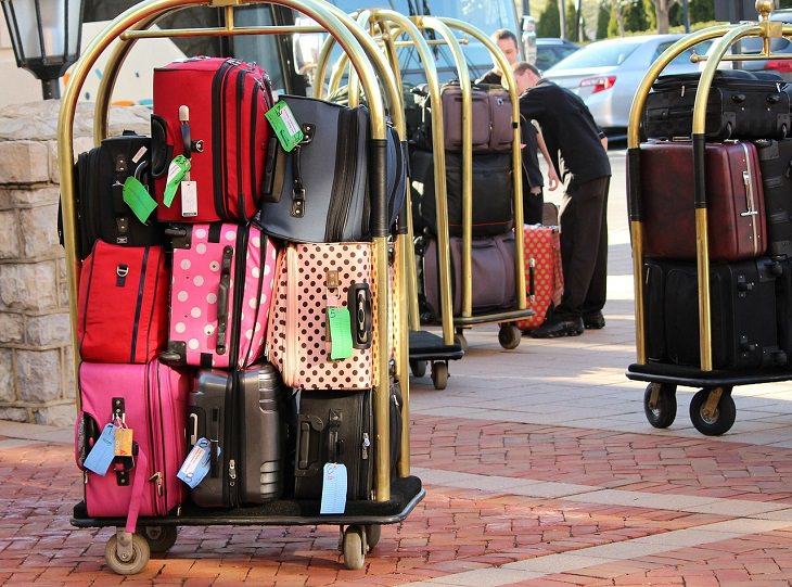 Tips for making the most of your next cruise trip, hotel trolley filled with suitcases of many different colors 