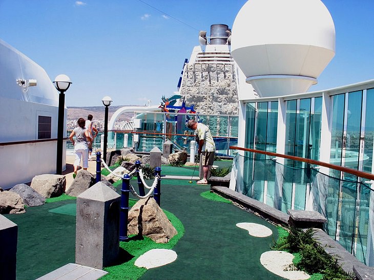Tips for making the most of your next cruise trip, man and woman on a cruise ship playing mini-golf