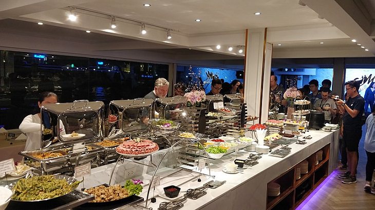 Tips for making the most of your next cruise trip, fully stocked and crowded buffet line in a cruise ship with servers and chefs present