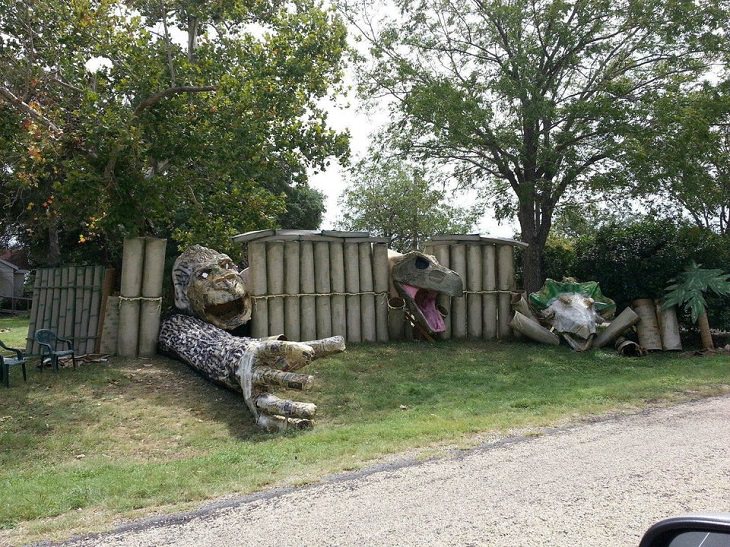 Most Incredible Halloween Decorations, fence with broken parts and King Kong, a T-Rex and a giant Venus Fly Trap coming through it