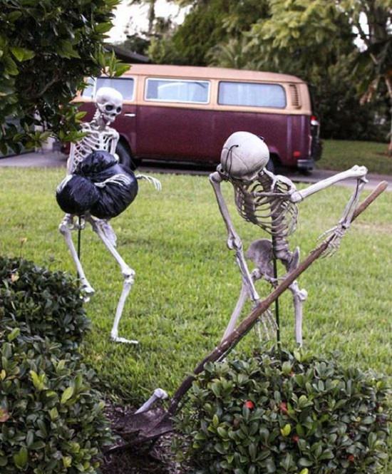 Most Incredible Halloween Decorations, two skeletons cleaning up garbage on the grass