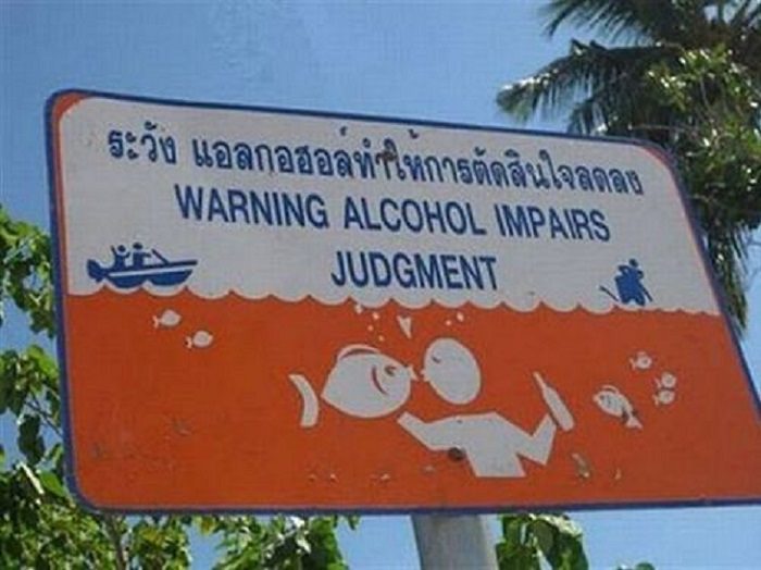 Funny warning and caution signs, warning sign that alcohol impairs judgment with a picture of a person kissing a fish
