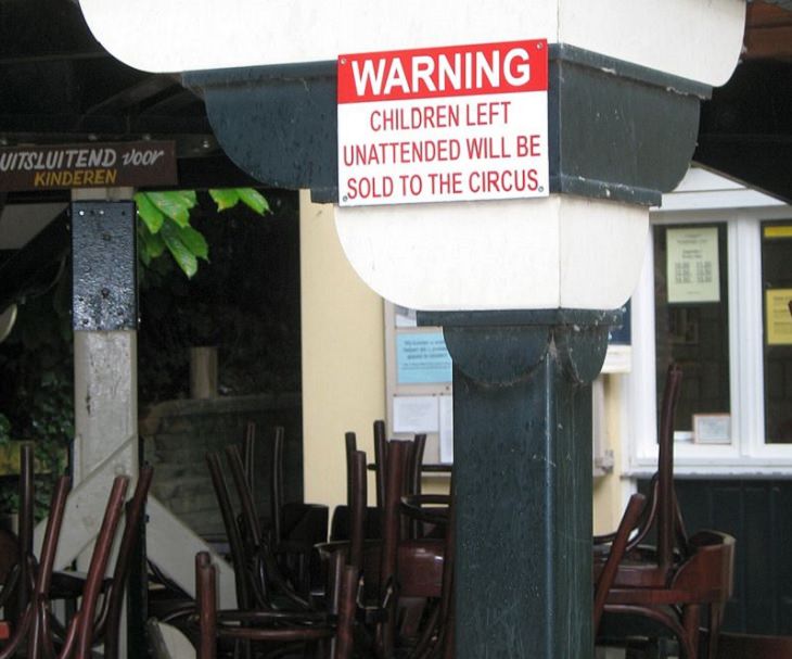 Funny warning and caution signs, sign in a restaurant warning that unattended children will be given to the circus