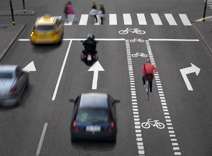 the dutch reach method of opening car doors for safety, busy street intersection wth bike lane