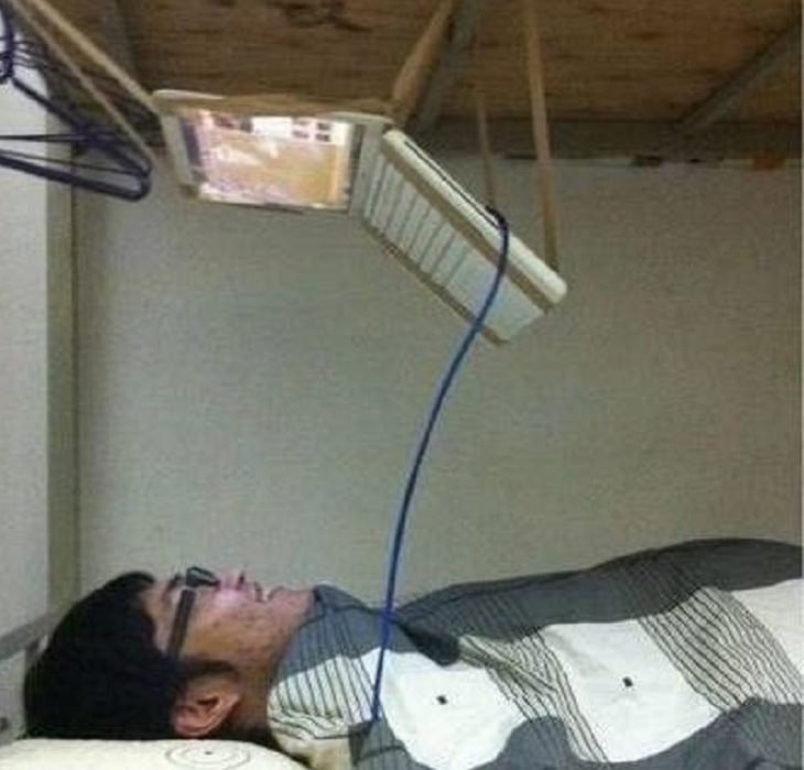 Hilarious but Smart Life Hacks, man lying down with laptop suspended from the ceiling