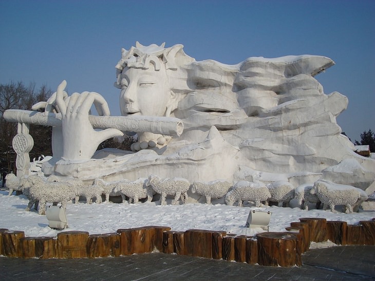 Snow Sculptures and Statues from Festival, Snow Sculpture of a mystical flutist at the Snow and Ice World festival in Harbin, China