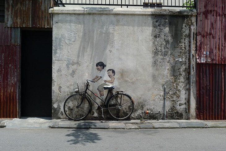 Beautiful Street art and graffiti murals from around the world, painting on a wall of two children riding a bicycle