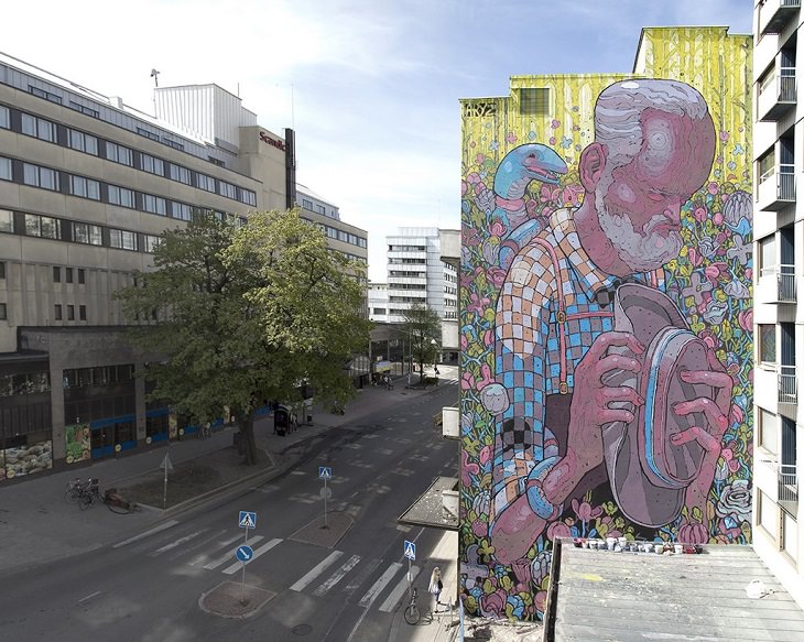 Beautiful Street art and graffiti murals from around the world, Aryz's mural in Finland (2011), blue and red mural of a man in a field of flowers holding his hat