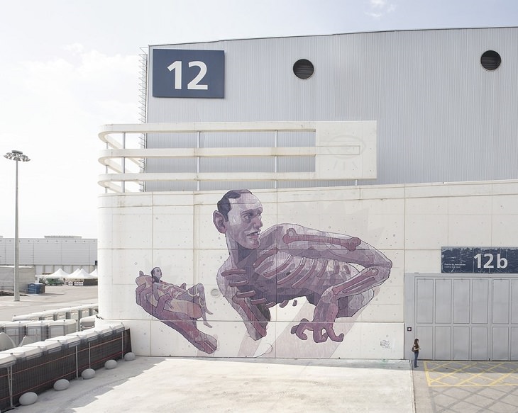 Beautiful Street art and graffiti murals from around the world, Aryz's mural in Madrid (2013), large man with a skeletal structure holding a hot dog bun with a small woman between the bun