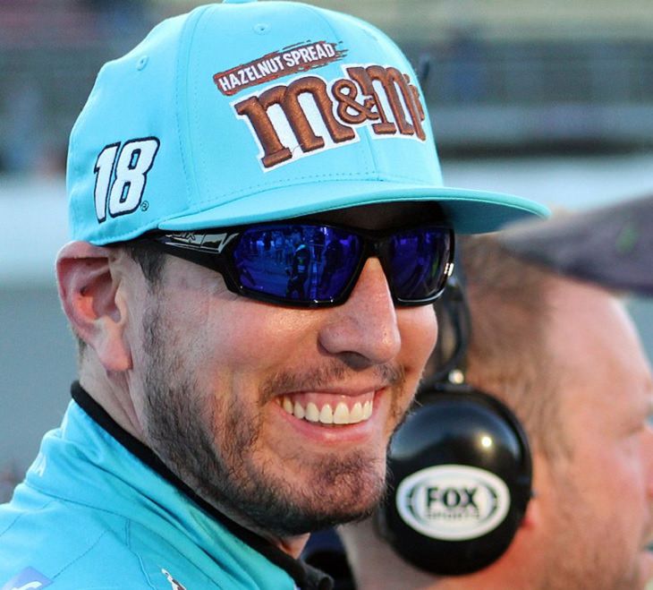 Top 19 NASCAR Race Drivers to Win Multiple Tracks, Kyle busch wearing blue M&M uniform and hat