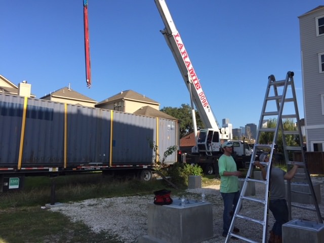 Will Breaux builds a house out of Eleven Shipping Containers, shipping containers being shifted with a crane