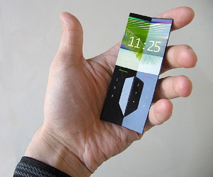 Incredible Scientific Inventions the Future Holds, holding a small chipped bluetooth phone in hand