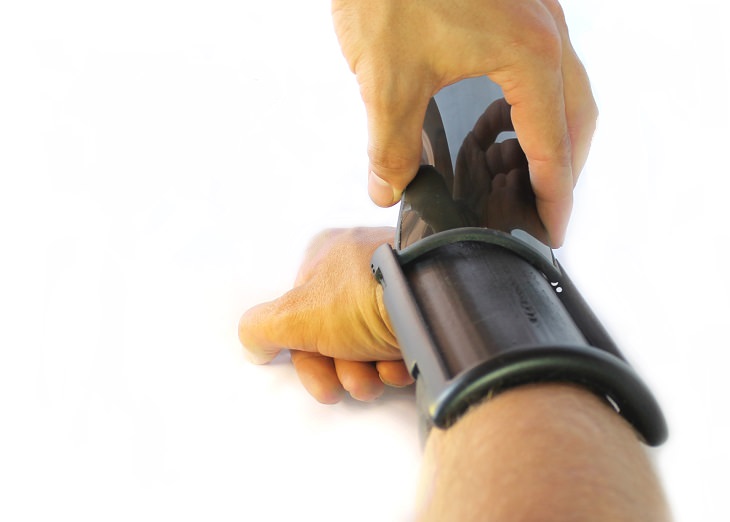 Incredible Scientific Inventions the Future Holds, man placing a flexible phone into an armband
