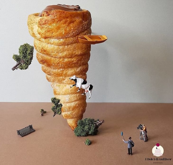 Beautiful Cakes Designed by Italian Chef, Large chocolate filled croissant in the shape of a tornado, with miniature bushes and a cow hanging on it and two miniature figures filming it