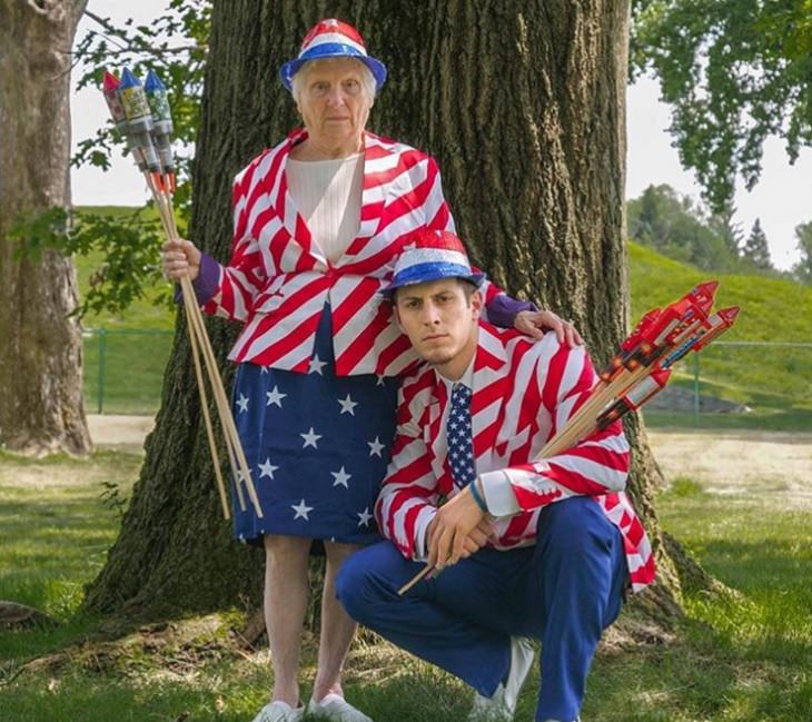 duo of grandmother and grandson, ross smith, wear fun costumes for social media, dressed in red, white and blue outfits holding firecrackers