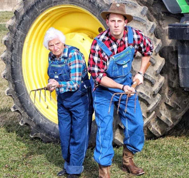 duo of grandmother and grandson, ross smith, wear fun costumes for social media, wearing farmwear, overalls with pitchfork in front of a tractor