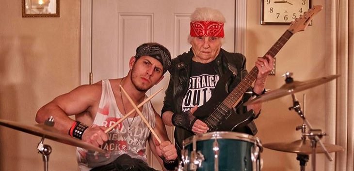 duo of grandmother and grandson, ross smith, wear fun costumes for social media, in rock star outfits playing the drums