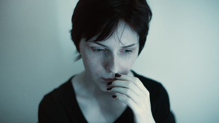 Debunking the myths about mental health, woman wearing black scoop-neck top touching her lips