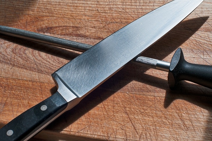 Common cooking mistakes and cooking tips, Large kitchen knife above sharpening tool