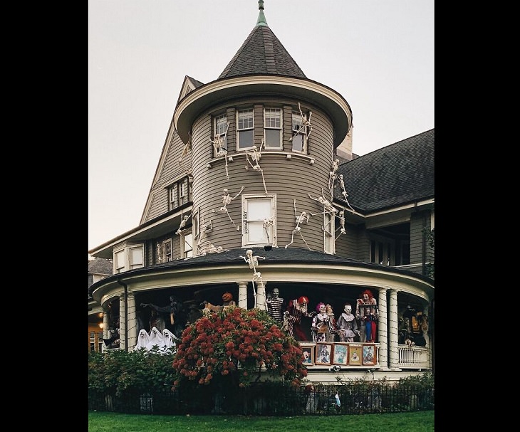 Creative and spooky halloween decorations from 2020, Costumed spooky creatures on the deck and skeletons climbing up the side of the house