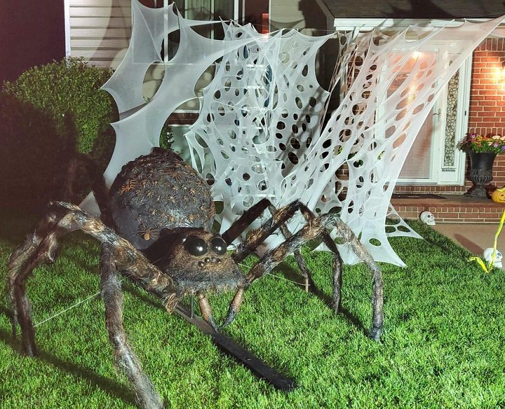 Creative and spooky halloween decorations from 2020, Giant model spider with thick webs behind in front house
