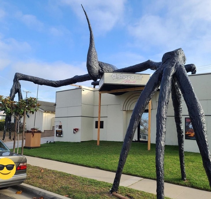 Creative and spooky halloween decorations from 2020, Large model of alien or monster with long legs climbing over a building