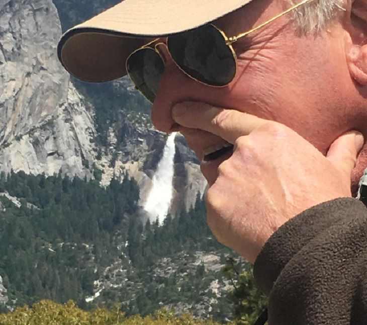 Clever and funny dads that win at parenting, Man holding nose in photograph with waterfall in the background