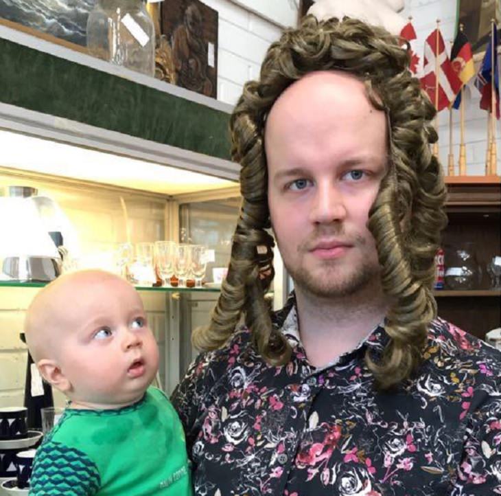 Clever and funny dads that win at parenting, Baby staring with surprise at father in a curly hair wig