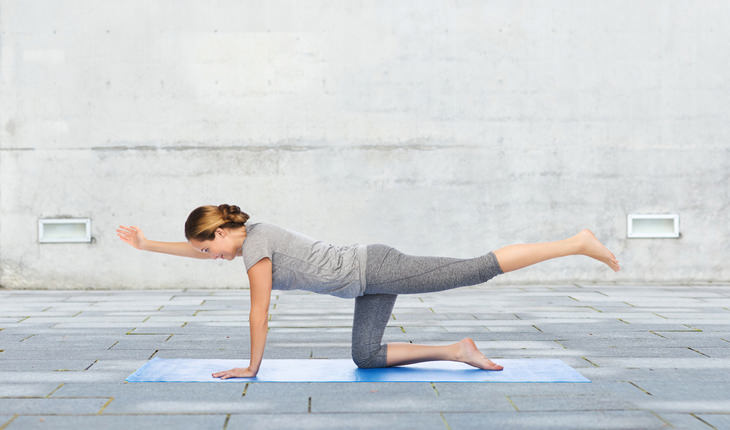 young woman doing Balancing Table  yoga position