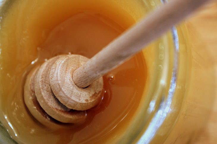 Common ingredients to be avoided in weight-loss smoothies, Wooden honey dipper being dipped in honey