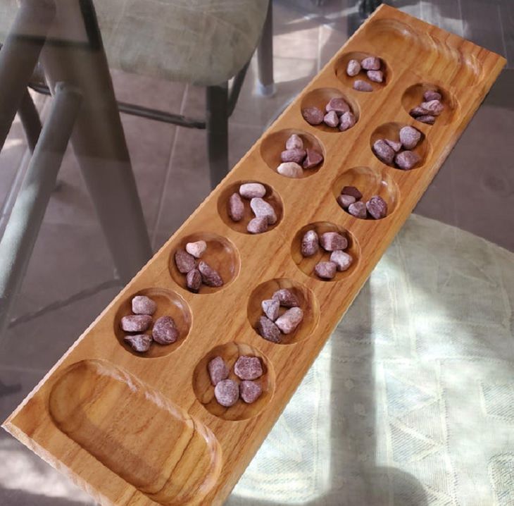 Oldest games played by ancient civilizations from around the world, Mancala board with small stones as game pieces
