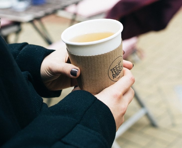 Names of everyday items you didn’t know, Girl holding a coffee cup with a cardboard sleeve, zarfs