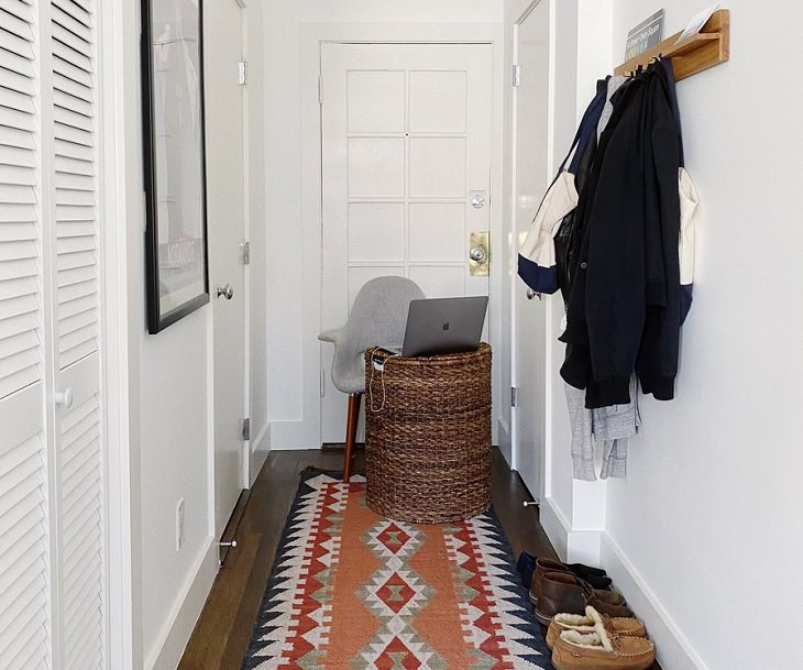 Funny improvised and makeshift work from home (wfh) workspaces and workstations, thin long corridor with chair and hamper at the end set up for working on the laptop