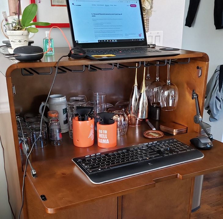 Funny improvised and makeshift work from home (wfh) workspaces and workstations, fully stocked liquor cabinet used as a work desk
