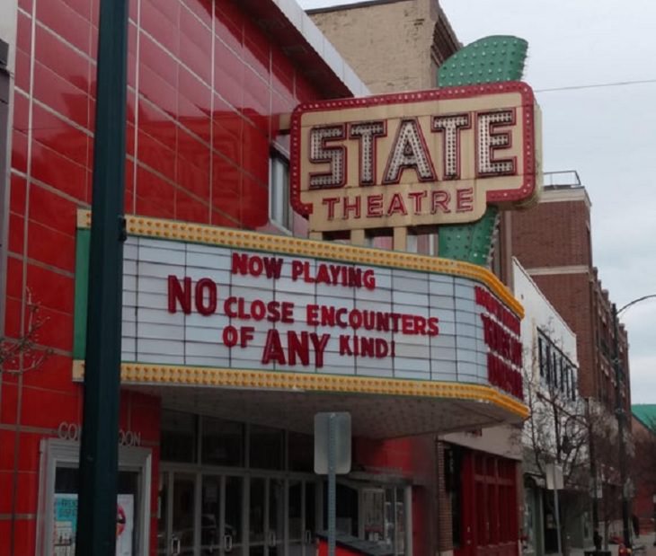 Funny signs related to the quarantine and lockdown caused by the COVID-19 (coronavirus) pandemic, State theatre sign saying “Now Playing, No close encounters of any kind”