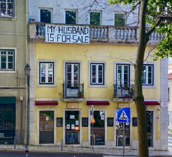 Funny signs related to the quarantine and lockdown caused by the COVID-19 (coronavirus) pandemic, large sign hanging off a balcony that says “My husband is for sale.”