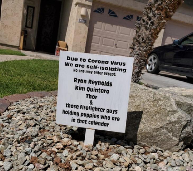 Funny signs related to the quarantine and lockdown caused by the COVID-19 (coronavirus) pandemic, sign on a lawn saying “Due to Corona Virus, we are self isolation. No one may enter except : Ryan Reynolds, Kim Quintero, Thor & those firefighter guys holding puppies who are in that calendar.”