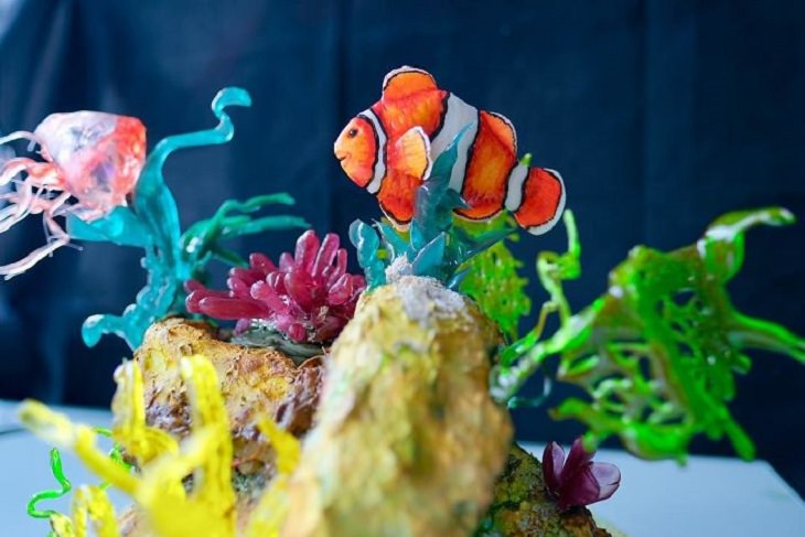Realistic and Delicious cake art by Turkish chef Tuba Gelick, cake of small clownfish swimming around coral