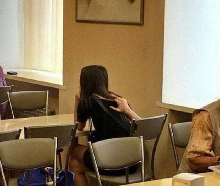 Photographs that will make you look twice or do a double take, Girl sitting at a table with a hand on her back