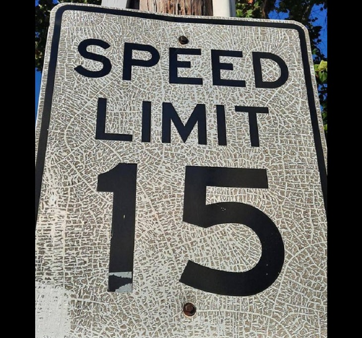 Photographs that will make you look twice or do a double take, Old speed limit sign with cracks that look like a map