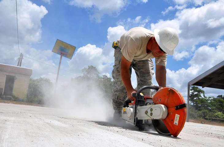 Household items that should not have the vacuum cleaner used on them, Man using electric saw on wooden platform