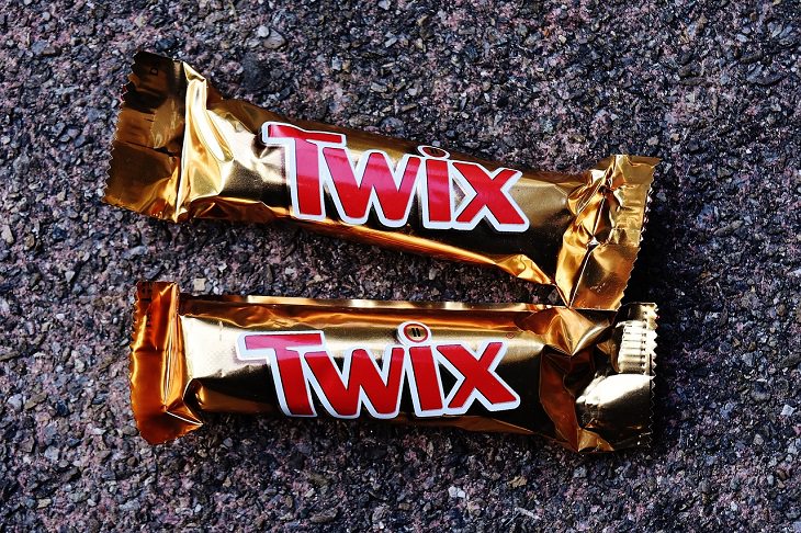 Downsizing and labelling marketing ploys done to trick Customers by big companies, Two twix bars on a table